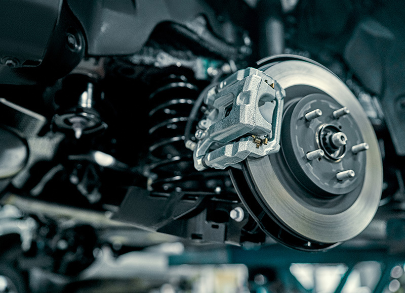 Close-up of a vehicle battery installed in the engine compartment, highlighting key engine components under the hood.