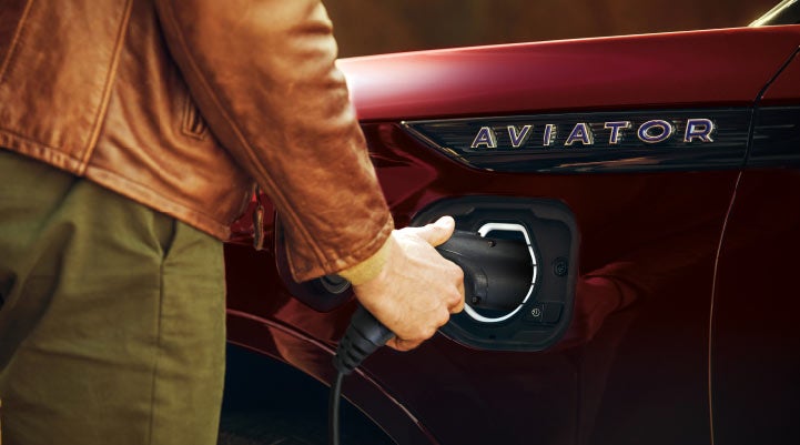 A hand is shown plugging in the charger into the charging port of a 2021 Lincoln Aviator | West Point Lincoln of Sugar Land in Houston TX