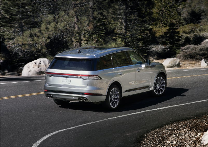 A 2023 Lincoln Aviator® Grand Touring model is shown being driven on a tight turn of a mountain road | West Point Lincoln of Sugar Land in Houston TX