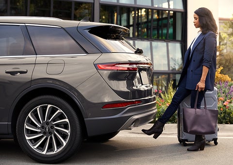 A woman with her hands full uses her foot to activate the available hands-free liftgate. | West Point Lincoln of Sugar Land in Houston TX