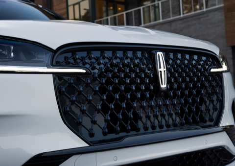 The black grille of a white 2025 Lincoln Aviator® SUV is shown with its fog lights on. | West Point Lincoln of Sugar Land in Houston TX