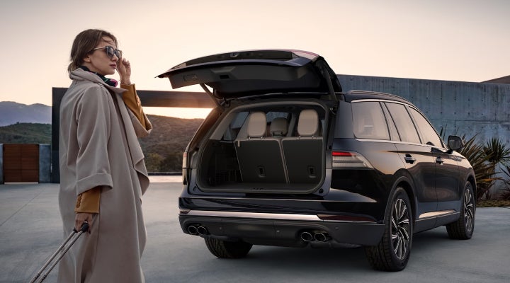 A woman approaches a 2026 Lincoln Aviator® SUV with its rear liftgate open. | West Point Lincoln of Sugar Land in Houston TX