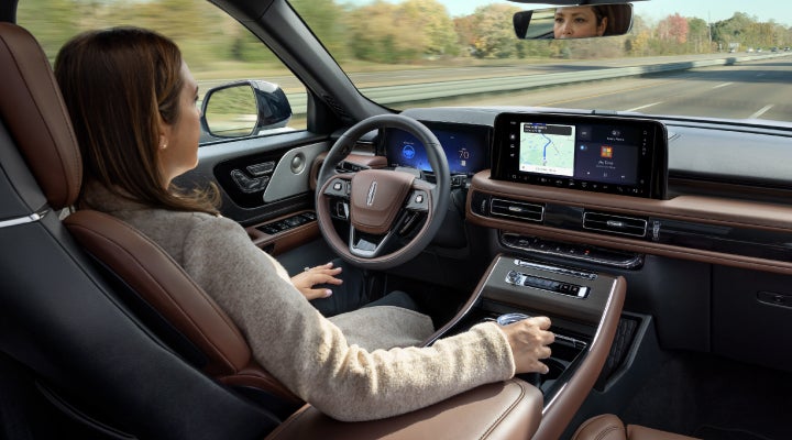 A 2026 Lincoln Aviator® SUV is being driven hands-free on a highway near a forest | West Point Lincoln of Sugar Land in Houston TX