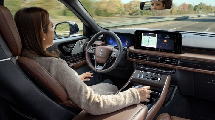 A 2027 Lincoln Aviator® SUV is being driven hands-free on a highway lined with trees. | West Point Lincoln of Sugar Land in Houston TX