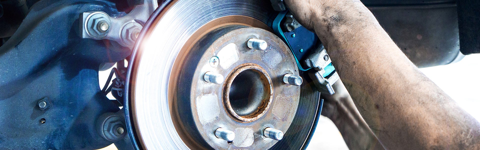 Close-up view of a vehicle brake rotor and caliper during automotive brake service.
